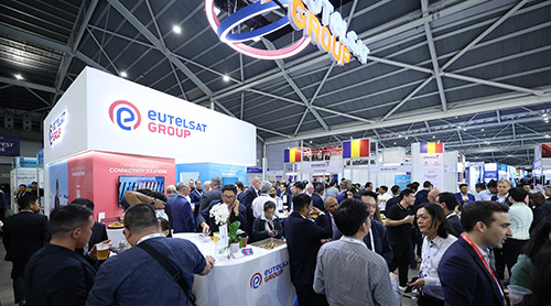 Attendees at ATxSG, Asia’s annual flagship tech event, networking at Eutelsats booth, discussing AI and digital economy in Singapore.